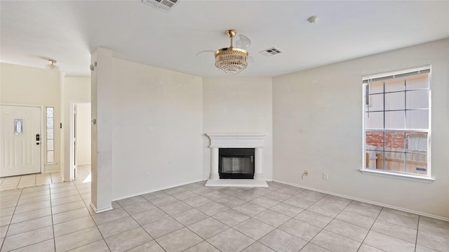 unfurnished living room with light tile patterned floors, visible vents, and a glass covered fireplace