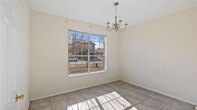 unfurnished dining area with a chandelier, tile patterned flooring, and baseboards