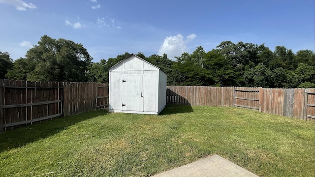 view of yard featuring an outbuilding, a storage shed, and a fenced backyard