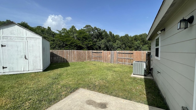 view of yard with an outbuilding, a storage unit, central AC unit, and a fenced backyard