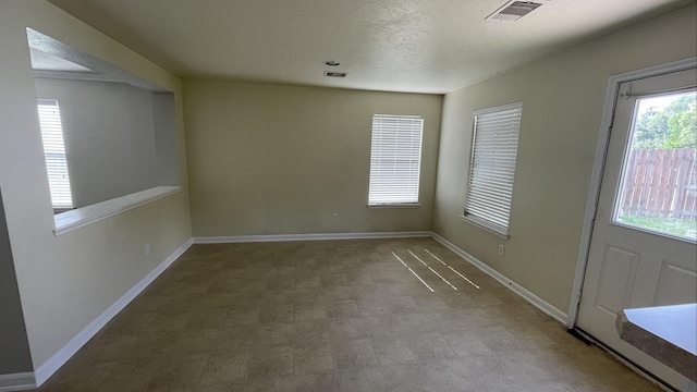 foyer entrance with visible vents, baseboards, and a textured ceiling