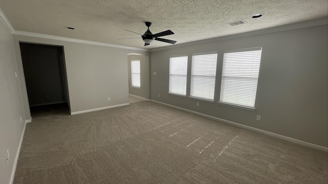 carpeted empty room with visible vents, baseboards, a textured ceiling, and ornamental molding