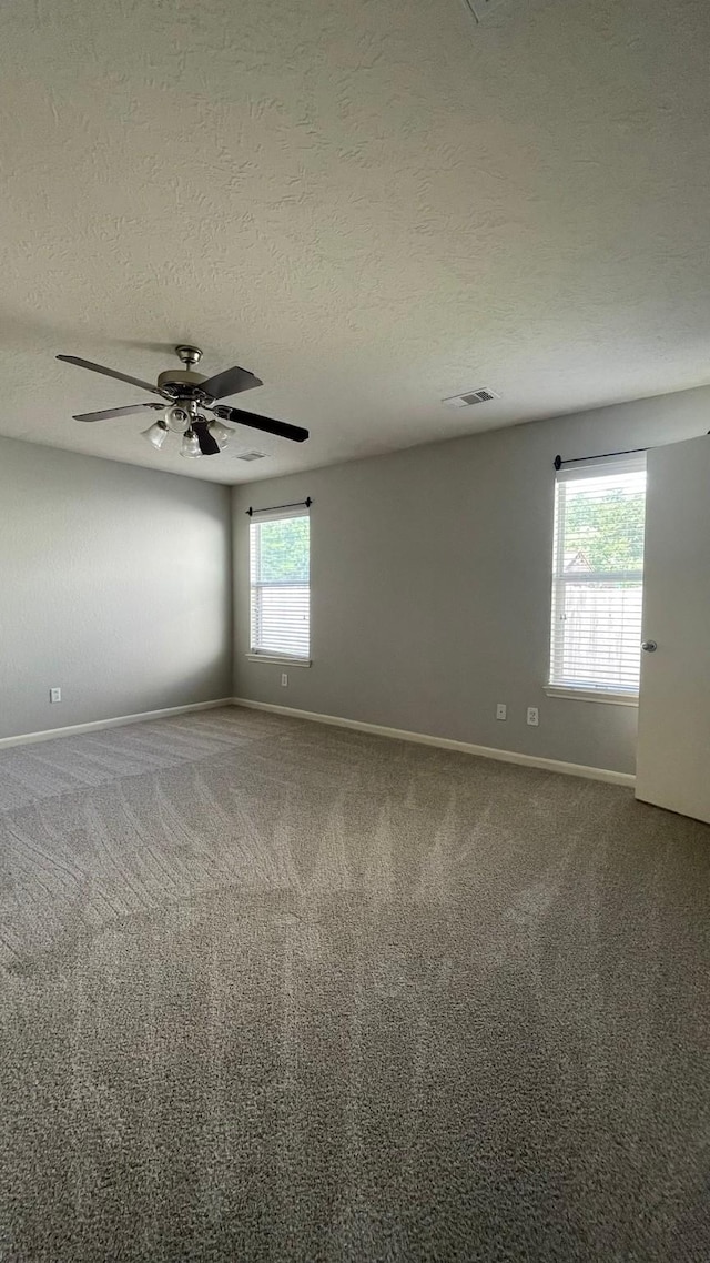 unfurnished room featuring carpet, baseboards, and a textured ceiling