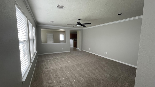 carpeted spare room with visible vents, ornamental molding, a ceiling fan, a textured ceiling, and baseboards