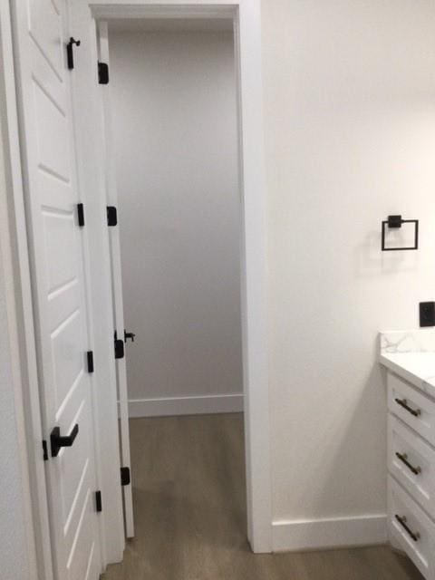 bathroom featuring vanity, wood finished floors, and baseboards