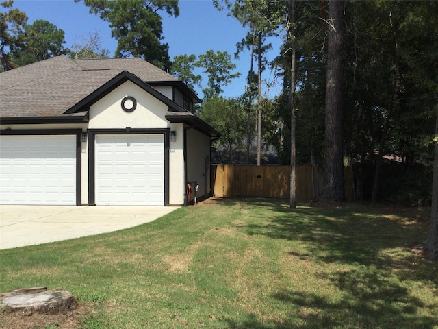 garage with concrete driveway and fence