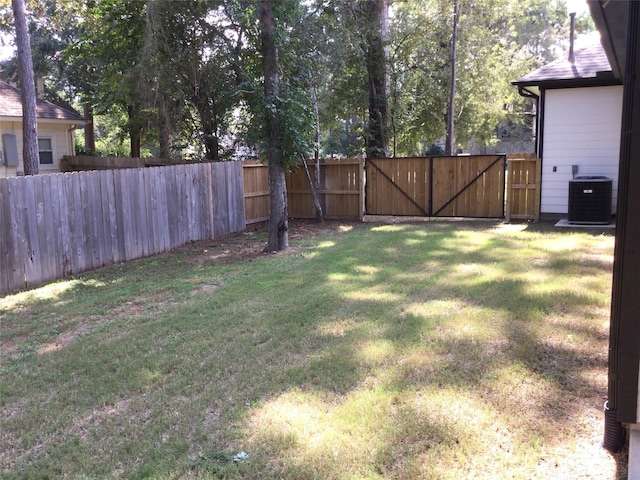 view of yard with a gate, cooling unit, and fence