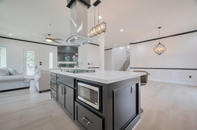 11706 Walden Rd, Montgomery, TX 77356 - kitchen with dark cabinetry, light wood-style flooring, stainless steel appliances, open floor plan, and island exhaust hood