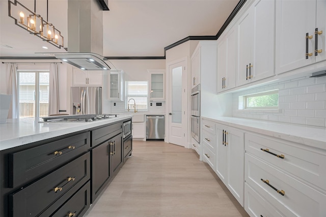 11706 Walden Rd, Montgomery, TX 77356 - kitchen featuring island exhaust hood, appliances with stainless steel finishes, backsplash, and white cabinets