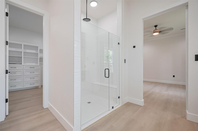 11706 Walden Rd, Montgomery, TX 77356 - full bath with a walk in closet, a ceiling fan, a shower stall, wood finished floors, and baseboards