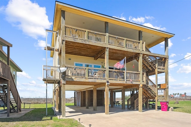 rear view of property with stairs, a carport, a deck, and driveway