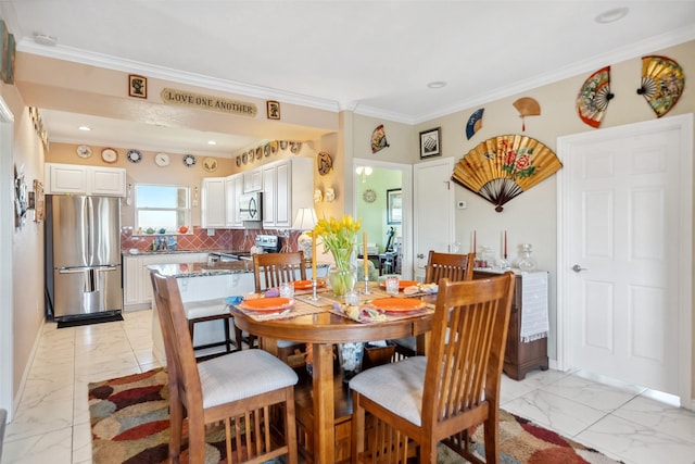 dining space with marble finish floor, crown molding, and baseboards