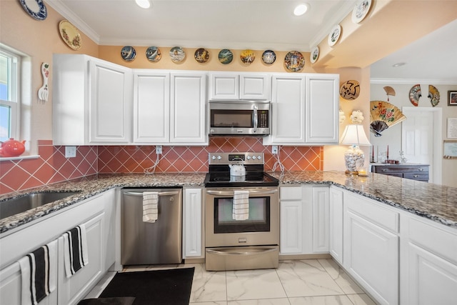 kitchen featuring marble finish floor, appliances with stainless steel finishes, white cabinets, and crown molding