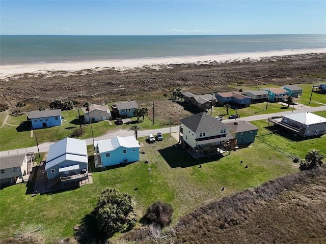 drone / aerial view with a view of the beach, a water view, and a residential view