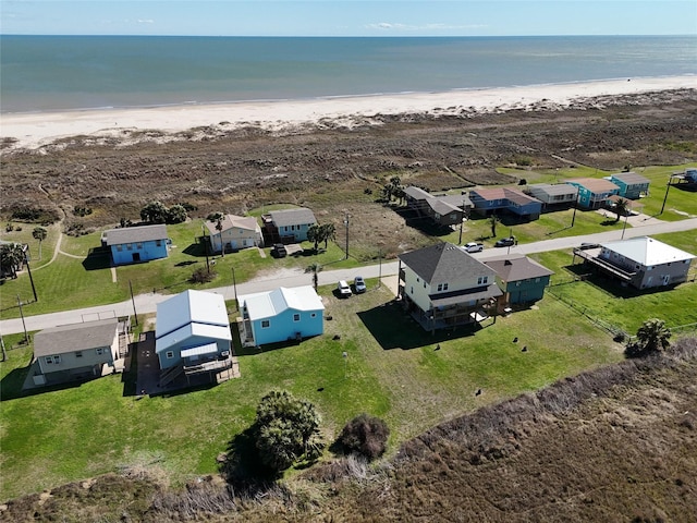 drone / aerial view featuring a residential view, a water view, and a beach view