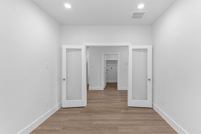 empty room featuring recessed lighting, light wood-style floors, visible vents, and baseboards