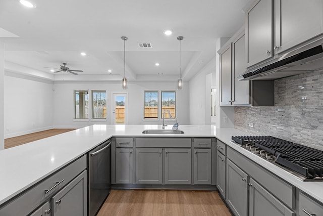 kitchen with gray cabinets, appliances with stainless steel finishes, light countertops, and a sink