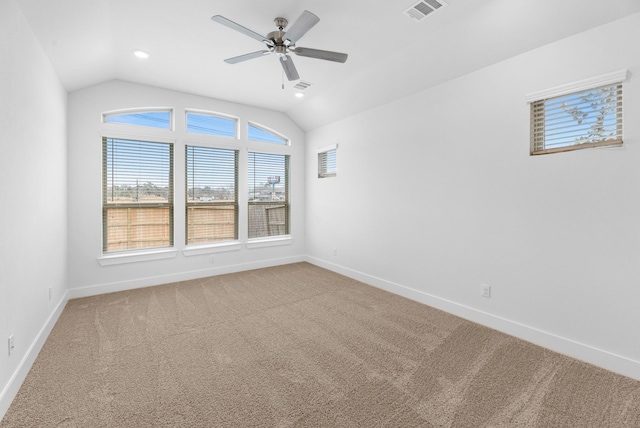 empty room featuring light carpet, visible vents, baseboards, and vaulted ceiling