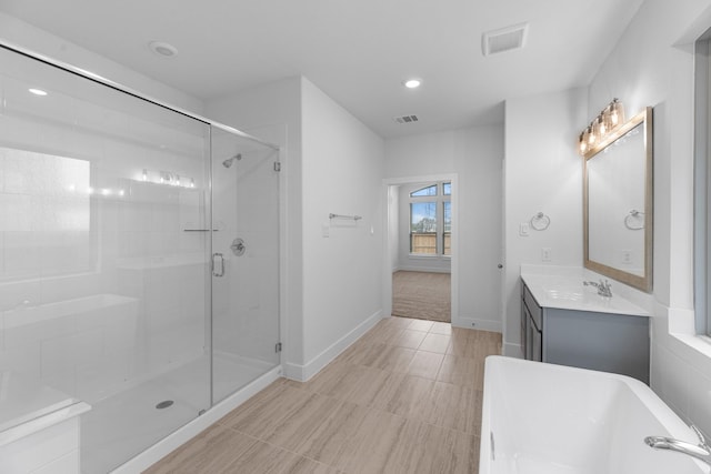 bathroom with visible vents, baseboards, a stall shower, a bath, and vanity