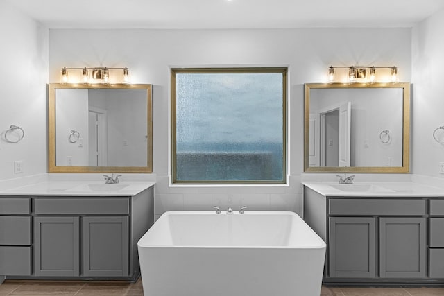 bathroom featuring plenty of natural light, two vanities, and a sink