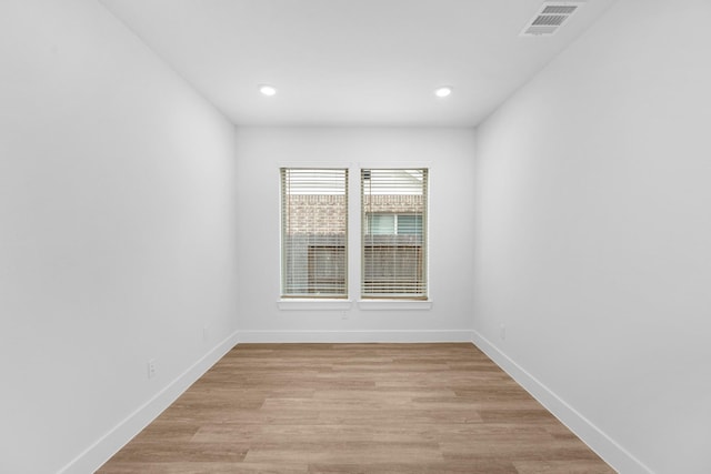 empty room with recessed lighting, light wood-style floors, visible vents, and baseboards