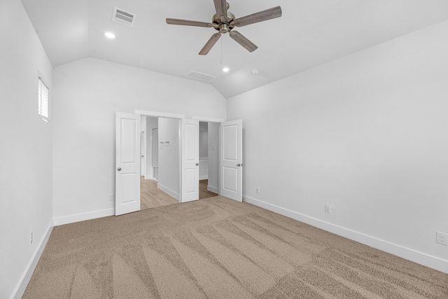 unfurnished bedroom with visible vents, carpet floors, baseboards, and vaulted ceiling