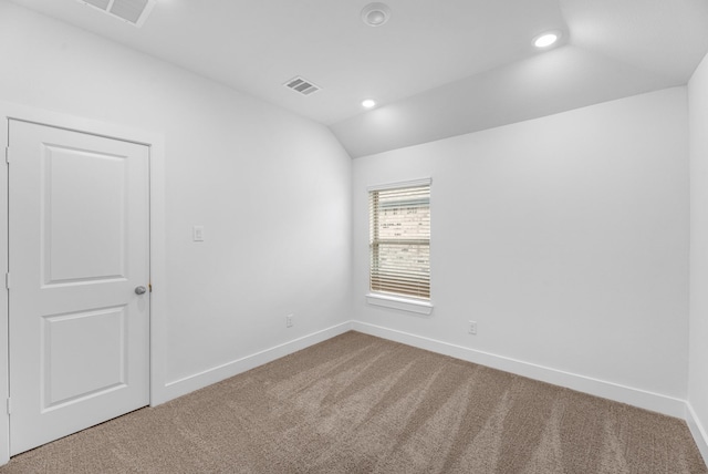 spare room featuring visible vents, recessed lighting, carpet floors, baseboards, and vaulted ceiling