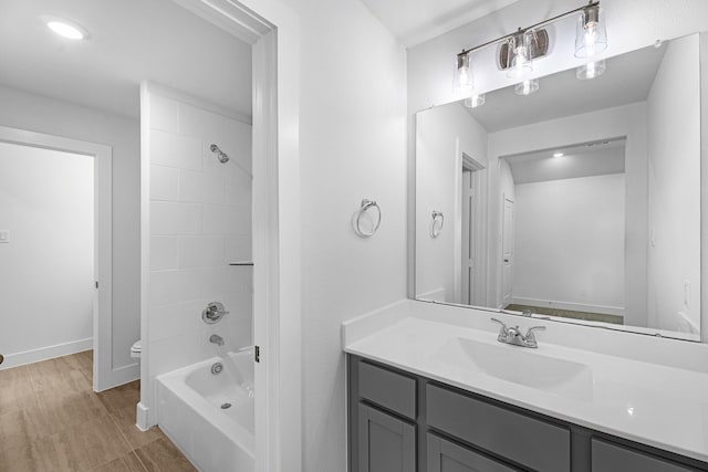 full bath with shower / bath combination, toilet, vanity, and baseboards