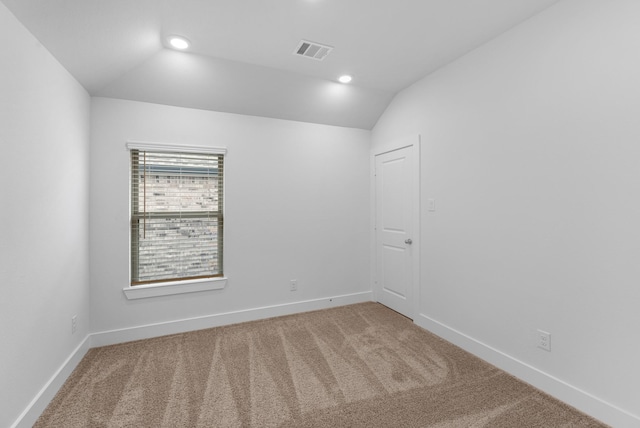 unfurnished room with lofted ceiling, baseboards, visible vents, and carpet floors