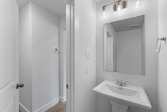 bathroom with a sink, visible vents, and baseboards