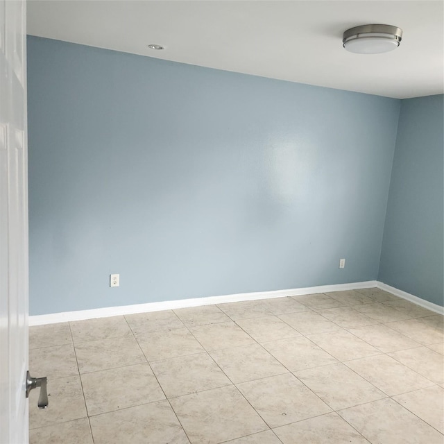 unfurnished room with light tile patterned floors and baseboards