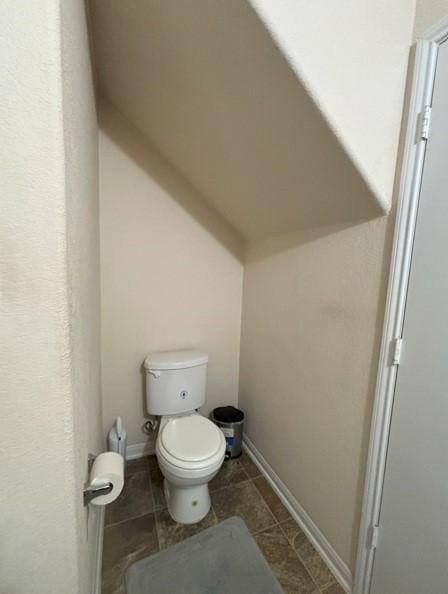 bathroom featuring toilet and baseboards