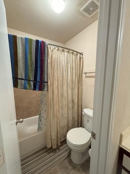 bathroom with tile patterned flooring, visible vents, toilet, shower / bath combo, and a textured ceiling