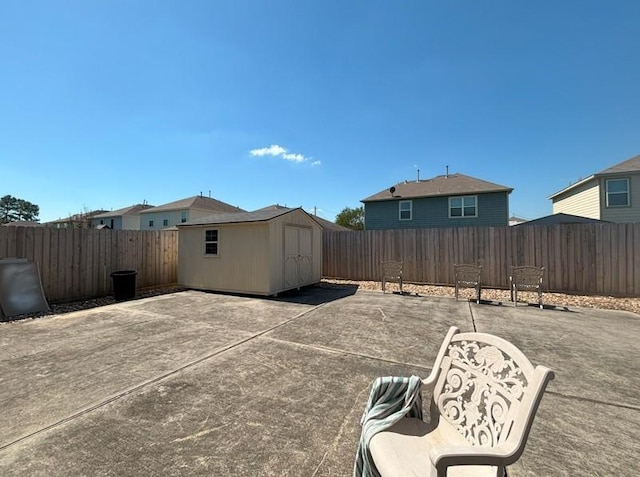 view of patio with an outbuilding, a shed, and a fenced backyard