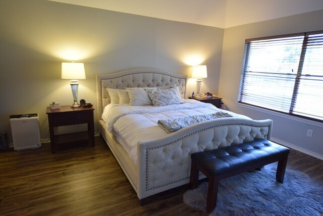 bedroom with wood finished floors and baseboards