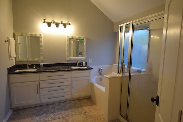 bathroom featuring vaulted ceiling, a garden tub, a stall shower, and a sink