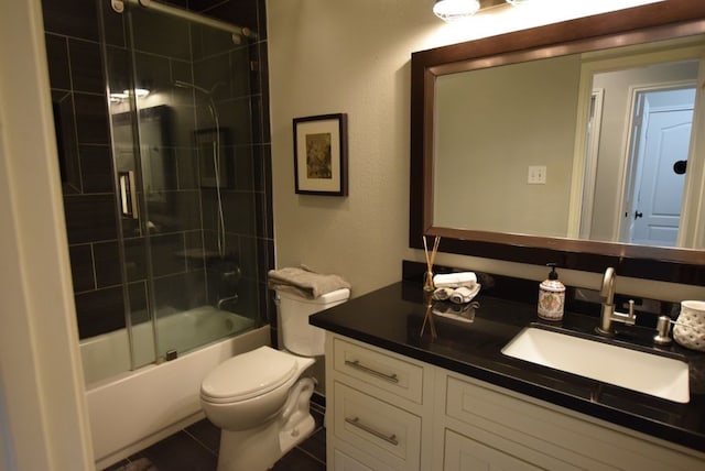 bathroom featuring combined bath / shower with glass door, toilet, and vanity