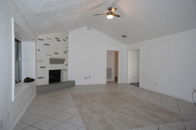 unfurnished living room with a ceiling fan, lofted ceiling with beams, light tile patterned floors, baseboards, and a brick fireplace