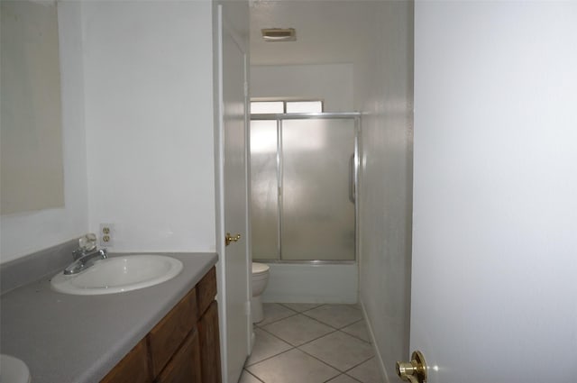 bathroom with vanity, tile patterned floors, toilet, and shower / bath combination with glass door