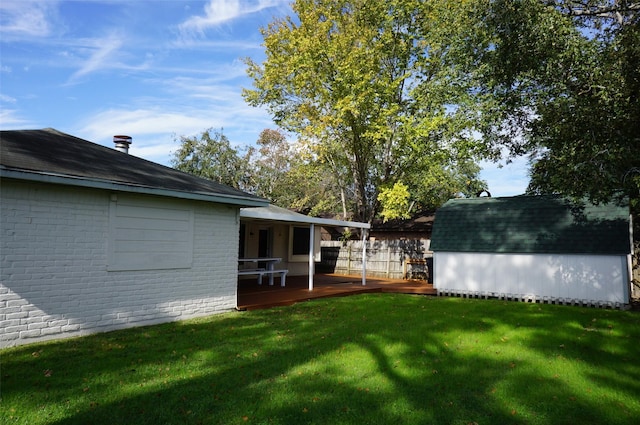 view of yard with a shed, a wooden deck, and an outdoor structure