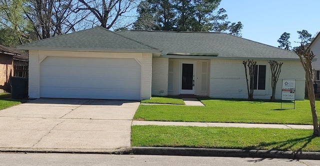 single story home with driveway, a front yard, a shingled roof, a garage, and brick siding