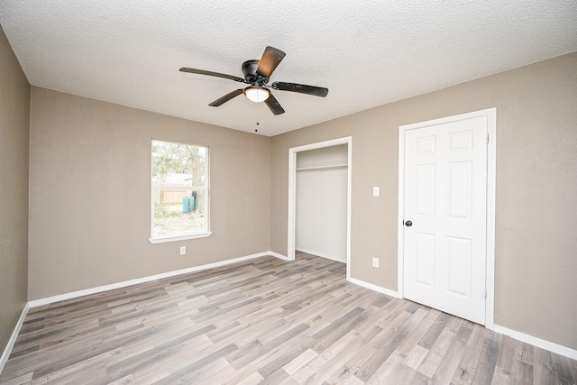 unfurnished bedroom featuring a closet, baseboards, and light wood finished floors