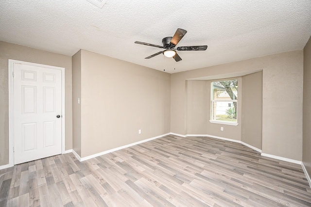 empty room with baseboards, light wood-style floors, ceiling fan, and a textured ceiling