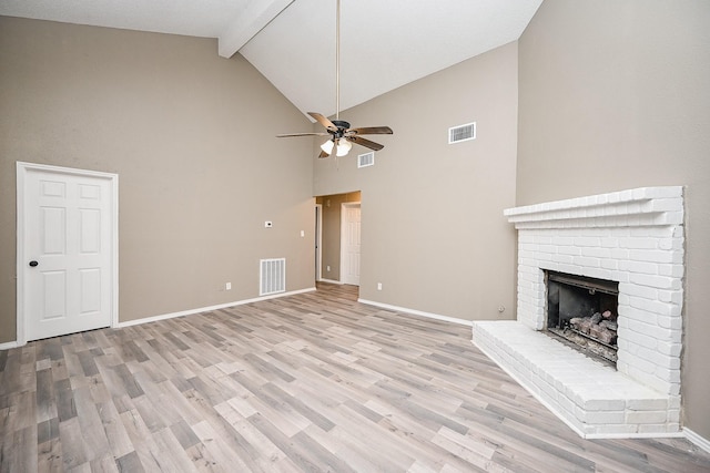 unfurnished living room with light wood-style flooring, a fireplace, and visible vents