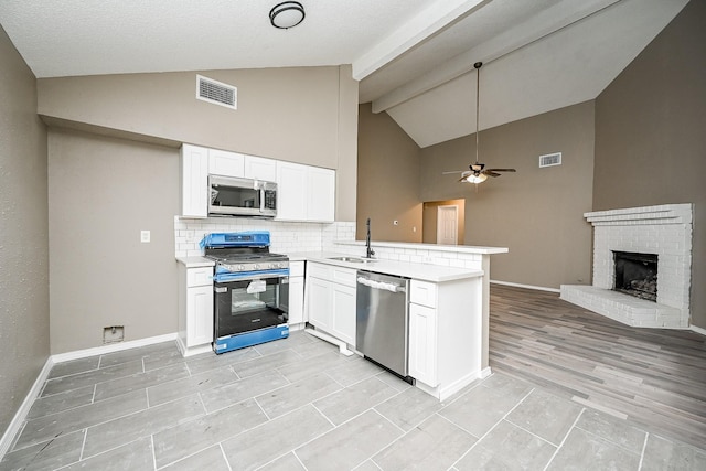 kitchen with a sink, a peninsula, visible vents, and stainless steel appliances