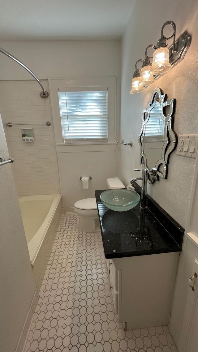 bathroom with shower / tub combination, toilet, vanity, and baseboards