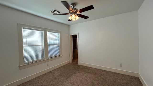 carpeted empty room with a ceiling fan, baseboards, and visible vents