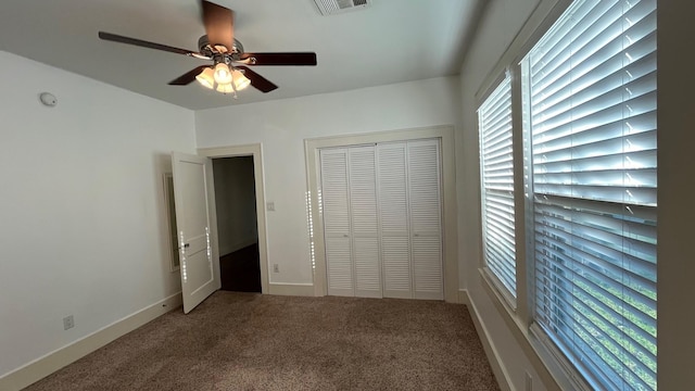 unfurnished bedroom featuring visible vents, a closet, carpet, baseboards, and ceiling fan