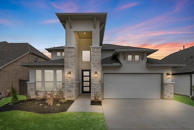 view of front of property featuring stucco siding, roof with shingles, concrete driveway, a garage, and brick siding