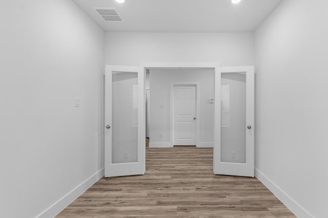 unfurnished room with visible vents, baseboards, and wood finished floors